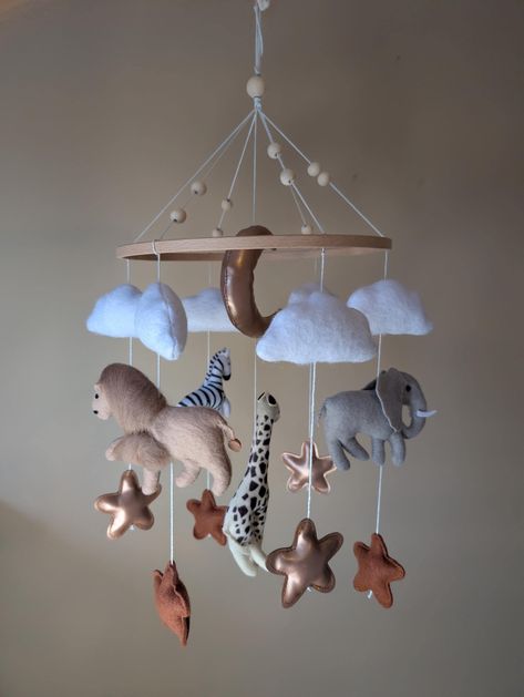 MOBILE ONLY- cot arm is not included. Personalised your gift with your little ones name or a special date.  This beautiful safari-themed baby mobile is the perfect addition to any nursery.  Handmade with love, it features adorable felt elephants, lions, zebras, and giraffes in a neutral color palette that will complement any décor. Features: * Neutral colors: beige, grey, white, and brown  * Wooden hoop  * Makes a great gift for a baby shower or Christmas This mobile is sure to stimulate your baby's imagination and provide hours of visual enjoyment. It's also a beautiful and unique piece of nursery decor. Order yours today and add a touch of the wild to your little one's nursery! Mobile Safari, Cot Toys, Crib Toys, Mobile Baby, Hanging Mobile, Wooden Hoop, Personalised Baby, Neutral Colour Palette, Safari Animals