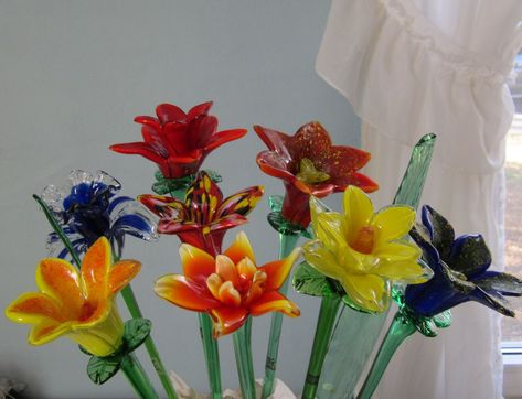 An assortment of our most popular glass flowers. They are all sold individually in price ranges from $9.99 to $14.99 Blown Glass Flowers, Glass Flower Bouquet, Soft Solder, Big Painting, Glass Bottles Art, Glass Pumpkins, Flower Display, Craft Room Organization, Glass Flowers