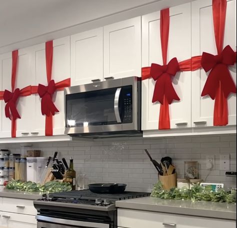 Decorating your kitchen for Christmas 🎄 Red Bow On Kitchen Cabinets, Red Ribbon On Kitchen Cabinets, Christmas Decoration Kitchen Cabinets, Cabnit Christmas Bow, Brown Cabinet Christmas Decor, Christmas Decor Ideas Renter Friendly, Kitchen Cabinet Ribbon Christmas, Christmas Decor Small Kitchen, Christmas Home Decor Kitchen