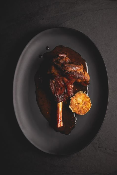 Brisket Photography Food Styling, Dark Aesthetic Food Photography, Lamb Shank Plating, Black Plate Food Photography, Plated Food Photography, Bistro Food Photography, Dark Cooking Aesthetic, Restaurant Photography Aesthetic, Dark And Moody Food Photography