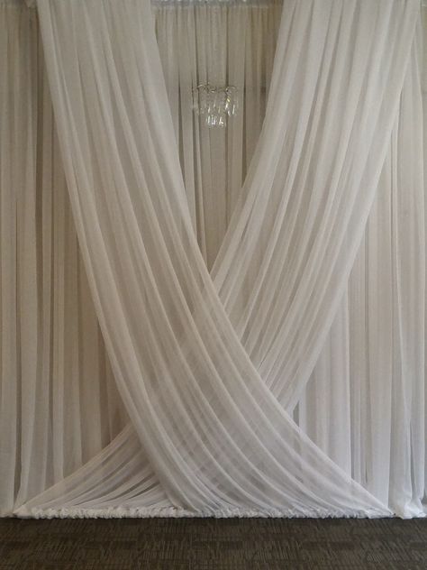 We created this gorgeous flowing backdrop for a wedding ceremony at the Royal Glenora Club in Edmonton, AB.  #weddingbackdrop #wedding ceremony #weddingceremonyideas #weddingceremonyinspiration Draped Alter Wedding, White Curtain Wedding Backdrop, Drapery Wedding Backdrop, Backdrop With Chandelier, Fabric Ceremony Backdrop, Wedding Drapery Ideas, Wedding Ceremony Draping, Drape Wedding Backdrop, Wedding Draping Backdrop