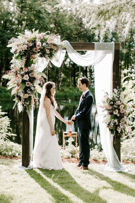 Wooden ceremony arch with tulle and flower arrangements  Click to see all 11 of our featured wedding ceremony backdrop and arch decoration ideas!   #weddingceremony #weddingflowerssummer #ceremonyarch #ceremonyarchoutdoors #ceremonyarchflowers #ceremonyarchgreenery #ceremonybackdrop #wedding #weddingceremony #ceremonyflowersalter #weddingceremonytulle Ceremony Arch Flowers, Ceremony Archway, Unique Wedding Ceremony, Wedding Archway, Arch Ideas, Wedding Ceremony Arch, Wedding Arbour, Wedding Altars, Wedding Ceremony Backdrop