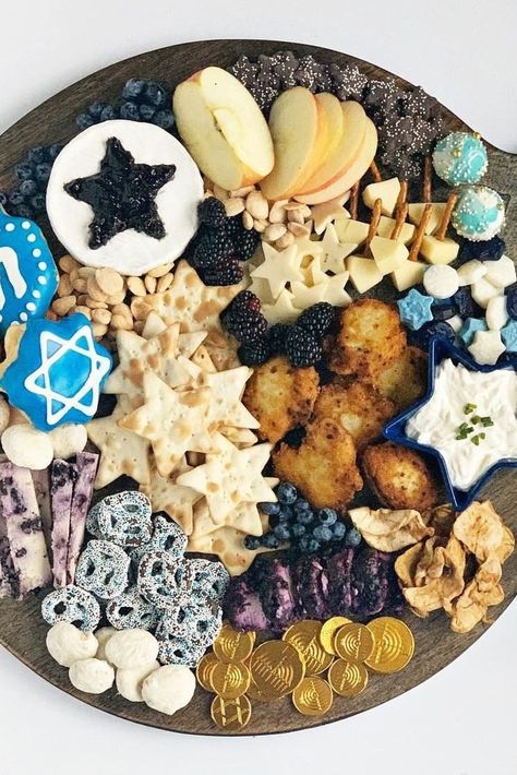 This Hanukkah charcuterie board has all the traditional charcuterie elements (cheese, crackers, fruit, and jam) but also includes some Hanukkah favorites—like latkes, chocolate gold coins, and dreidel-shaped cookies. #hanukkah #hanukkahcharcuterieboards #hanukkahideas #bhg Chrismukkah Party, Hanukkah Party Food, Hanukah Appetizers, Hannukah Recipes, Hanukkah Desserts, Hanukkah Traditions, Hanukkah Food, Chanukah Party, How To Celebrate Hanukkah