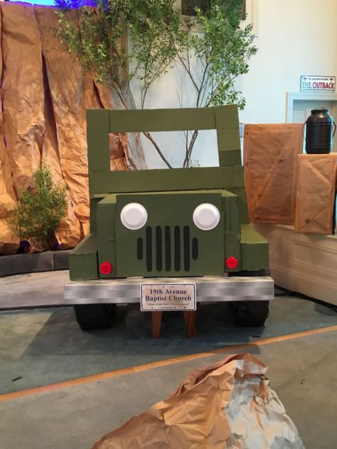 Cardboard Jeep. I'm a little bummed that the windshield bent in transport but it still turned out pretty nice. Bumper covered with "metal" ducttape from Dollar General. Foam plate headlight, bottom of Solo cup runner lights (I guess that's what they're called). Cardboard Jeep Photo Prop, Cardboard Jeep Diy, Safari Jeep Cardboard Diy, Jeep Photo Booth, Cardboard Jeep, Diy Safari Decorations, Zoomerang Vbs, Safari Party Decorations, Vbs Decorations