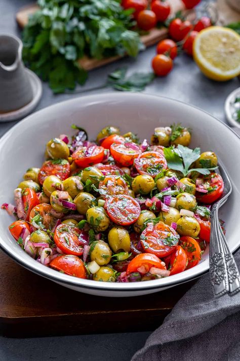 Discover the vibrant flavors of this refreshing Green Olive Salad, packed with fresh ingredients like tomatoes, onions, and herbs. This healthy and delicious salad is elevated by a tangy dressing made from lemon juice, sumac, and pomegranate molasses. Perfect as a side dish, light lunch, or potluck favorite, you'll love how the unique combination of ingredients creates a satisfying and unforgettable taste experience! Tomato And Olive Salad, Tomato Olive Salad, Super Salads Recipes, Green Olive Recipes, Olives Salad, Green Olive Salad, Santa Cupcakes, Salad Recipes Lunch, Unique Salad