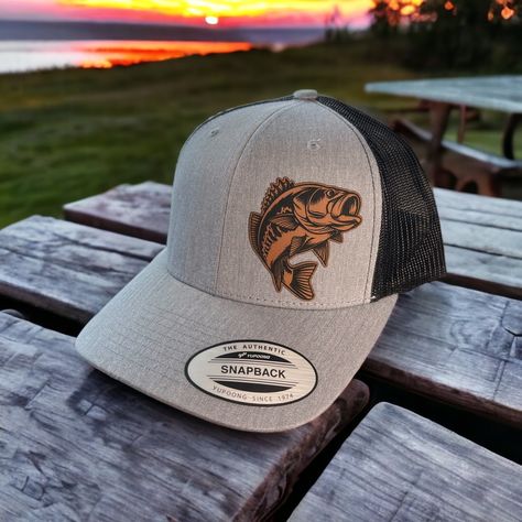 This is a custom made leather patch Hat!   These are made to order. Hat brand is Yupoong 6606 ! Trucker  style Hat with a SnapBack design.  Custom  Bass Patch design perfect for those awesome fishing days !  Please choose your color of hat you would like and color of patch.  Hat pictured is heather gray /black with rawhide patch.  Leather Patches are bonded to all hats **not stitched on** We use a powerful leather bonding and heat pressed for maximum bonding to the hat .  If you want a specific Leather Hat Patch Ideas, Leather Patch Hat Ideas, Leather Patch Hat Design, Leather Patches On Hats, Camping Hats, Men’s Hats, Sublimation Hats, Leather Patch Hats, Hat Patch Ideas