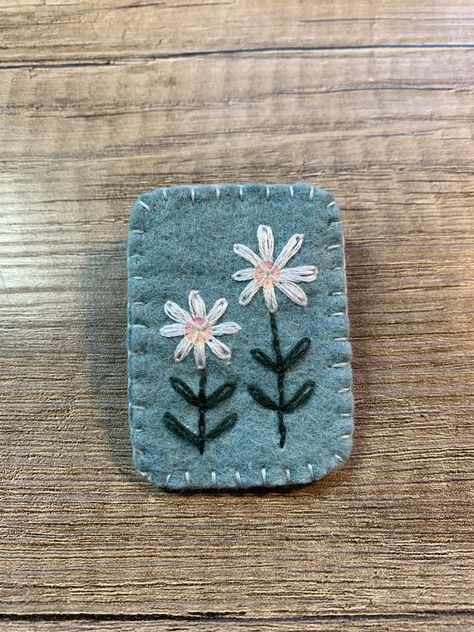 A handmade felt brooch with embroidered daisies with sequin detail Felt Pins Brooches, Felt Brooch Diy, Crafts With Felt, Felt Pins, Felted Accessories, Felt Patches, Sewing Felt, Embroidered Daisies, House Quilt Patterns