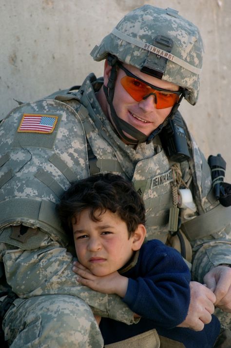 An Iraqi boy rests on the arm of U.S. Army Cpl. James Reinhard outside an Iraqi police department in Baghdad, Iraq.  DoD photo by Petty Officer 1st Class Bart A. Bauer, U.S. Navy. Baghdad Iraq, Us Soldiers, Military Heroes, Real Hero, We Are The World, Military Police, American Soldiers, U S Navy, Military Life