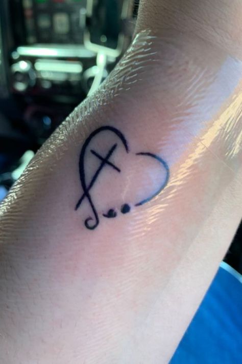 25 Amazing Heart Tattoos For Women To Try In 2023 Semicolon Tattoo Faith, Small Heart Semicolon Tattoo, Heart Faith Tattoo, Faith Tattoo With Semicolon, Heart With Semicolon Tattoo, Simple Faith Tattoos, Cross And Semicolon Tattoo, Cross Semicolon Tattoo, Cross With Heart Tattoo