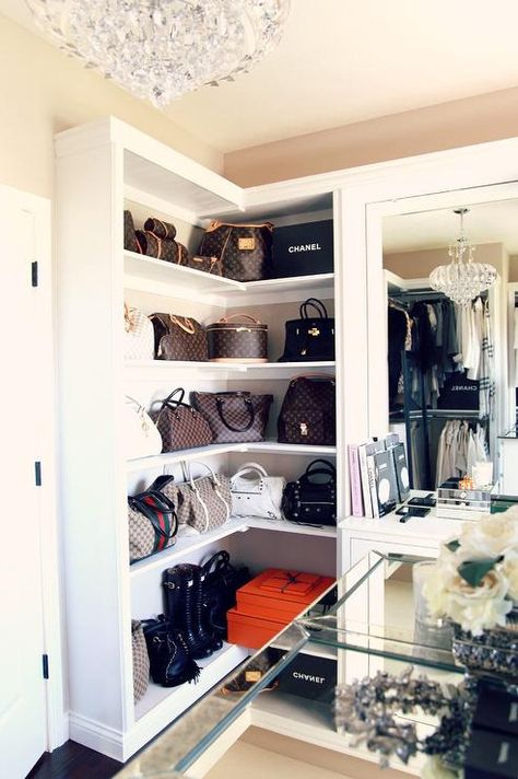 Designer bags sit against a beige wall atop built in white wrap around shelves positioned beside a dresser vanity accented with a mirror illuminated by a crystal chandelier. Toddler Closet Organization, Organization Shoes, Organiser Son Dressing, Toddler Closet, Trendy Closet, Shoe Station, Master Closet Organization, Shoe Organization, Shoes Organizer