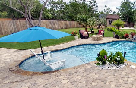 7 Affordable, Stylish Gunite Pool Features to Consider Swimming Pools Lighting, Gunite Pool Ideas With Tanning Ledge, Affordable Pool Ideas, Affordable Pool Ideas Backyard, Gunite Pool With Tanning Ledge, Affordable Inground Pool Ideas, Gunite Pool Ideas, Pool Waterfall Ideas, Gunite Pools