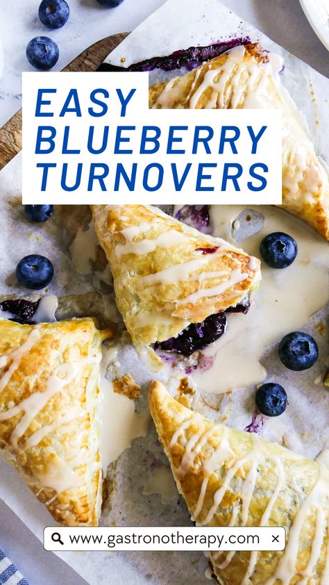 Five blueberry turnovers arranged on parchment paper with icing and fresh blueberries. Easy Blueberry Turnovers, Puff Pastry Recipes Turnovers, Blueberry Turnovers With Pie Crust, Puffed Pastry Turnovers, Puff Pastry With Blueberries, Blueberries Puff Pastry, Puff Pastry Frozen Berries, Easy Recipes Using Frozen Puff Pastry, Fruit Turnovers With Pie Crust