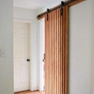 What an amazing DIY wood slat sliding door! You can make yours- follow the step by step tutorial! #diyslidingdoor #diybarndoor Utility Ideas, Brick Ranch Houses, Diy Built In, Office Doors, Modern Sliding Barn Door, Diy Sliding Door, Sliding Wood Doors, Timber Slats, Barn Door Designs