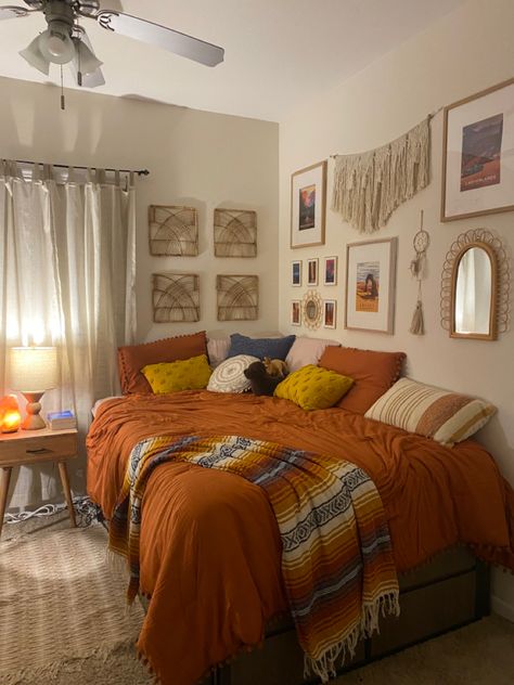 Mexico Themed Bedroom, Boho Granola Bedroom, Granola Room Inspiration, Warm Home Aesthetic Bathroom, Boho Bedroom With Carpet, Orange Bedspread Room Ideas, Bohemian Bedroom Plants, Boho Western Bedroom Decor, Boho Apartment Bedroom