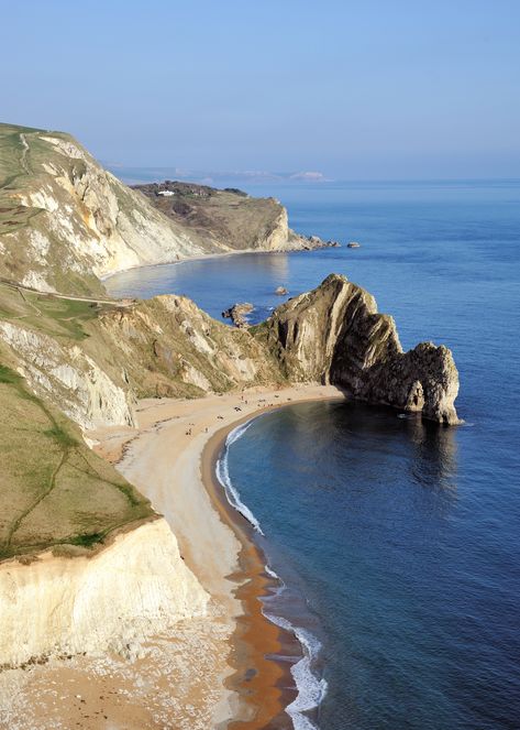 Durdle Door is a natural limestone arch on the Jurassic Coast near Lulworth in Dorset, England. Author: Saffron Blaze. This file is licensed under the Creative Commons Attribution-Share Alike 3.0 Unported license -- learn more about it on the website. #rock  #stone #arch #beach #seashore #ocean #mountain #sky #sand #beige #blue #sunny Beautiful Places In England, Durdle Door, Dorset Coast, Kentish Town, Places In England, Dorset England, Jurassic Coast, English Countryside, England Travel