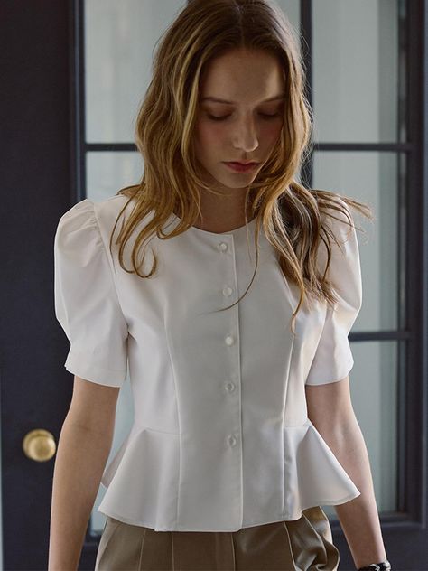 This product is a Puff Sleeve Blouse that offers a vintage-inspired charm combined with modern tailoring. It features a cinched waist that flares out slightly to create a flattering peplum effect. The blouse is distinguished by its voluminous puff sleeves which add a dramatic flair and draw attention to the shoulder line. - This blouse showcases a row of neat button closures down the front, adding a classic touch to its overall design.- Constructed with a structured fit, it enhances the waistline while providing a comfortable wear.- Puff sleeves are designed with pleated details to maintain their shape and provide a bold aesthetic.- Its versatile style allows it to be paired effortlessly with both casual jeans and formal skirts, making it suitable for diverse occasions. Peplum Top With Flared Jeans, Peplum Blouse With Skirt, Couture, Formal Blouse Patterns, Vintage Blouse Designs, Puffed Sleeves Blouse Saree, Puff Sleeve Blouse Outfit, Skirt Blouse Outfit, Structured Outfits