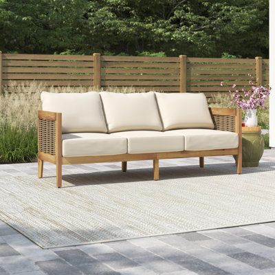 This patio sofa gives you a spot to relax on your porch or deck. It has a streamlined UV- and water-resistant solid acacia wood frame that rests on slightly tapered legs and features curved back corners for a graceful look. We love how the brown finish brings out the wood's natural grain for a coastal farmhouse feel. Breathable wicker rattan side accents and an open back complete the design. Beige-toned polyester cushions provide just the right amount of support as you enjoy casual coffee chats Outdoor Patio Sofa, Sofa With Cushions, Patio Daybed, Patio Couch, Buffet Console, Outdoor Couch, Aluminum Patio, Sunbrella Cushions, Teak Outdoor