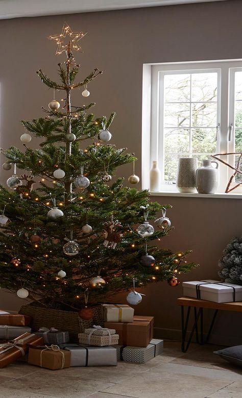 Give the classic Scandi style a festive twist. Select a real Christmas tree like the Nordmann spruce and then hang earthy toned baubles, wooden textures and a touch of copper to bring the cosy Hygge look in this Christmas.  Click for more festive tree decoration ideas.  From B&Q Christmas Tree Inspo, Copper Christmas, Hygge Christmas, Small Christmas Tree, Real Christmas, Scandi Christmas, Real Christmas Tree, Christmas Classic, Christmas Interiors