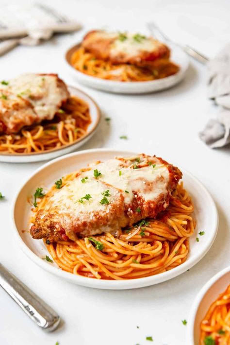 This Chicken Parmesan recipe is made with perfectly seasoned crispy chicken topped with a simple homemade tomato sauce and sliced mozzarella cheese. Pan-seared to develop the crust, then finished in the oven, we love to serve our chicken parm with spaghetti cooked just until al dente and tossed in more of the homemade sauce. | chicken parmesan recipe easy | chicken parmesan pasta | homemade chicken parmesan recipe | homemade chicken parmesan sauce recipe | chicken parmesan with spaghetti recipe Spaghetti And Chicken Parmesan, Chicken Parmesan With Pasta, Chicken Parmesan With Spaghetti, Homemade Chicken Parmesan, Chicken Parm Recipes, Chicken Parmesan Recipe Easy, Chicken Parmesan Recipe, Chicken Parmesan Pasta, Parmesan Recipe