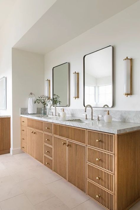 Picture of a large fluted double vanity with a stone countertop, brass knobs, stylish mirrors, sconces and greenery Studio Mcgee Double Vanity, Bathroom Vanity Between Two Walls, Vanity Between Two Walls, Bathroom Sconces Double Vanity, Double Vanity Mirror Ideas, Carved Sink, Mirror And Sconces, Terrazzo Sink, Colorful Outdoor Furniture