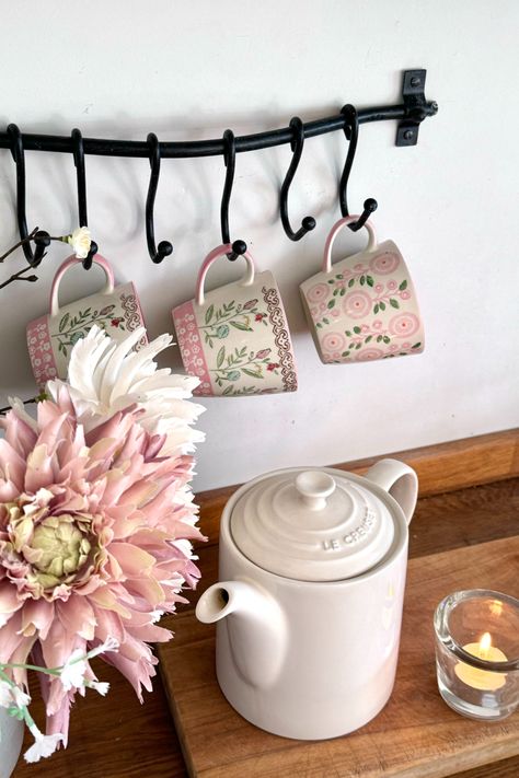 Elegantly hang your favorite mugs over a cosy tea making corner of your kitchen, using our curved utensil rail with S hooks.
Vintage style mug hanging rail for tea and coffee corner to style aesthetic mugs, the black hardware contrasts with the pink floral design of the mugs and light le creuset tea pot. Pink La Creuset, Le Creuset Pink Collection, Le Creuset Heart Mug, Le Creuset Pink, Le Creuset Cups Mugs, Le Creuset Shell Pink, Aesthetic Mugs, Tea Making, Pink Mug