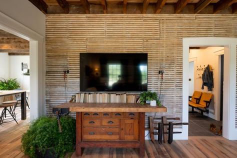 Jon and Kristina reimagined his family’s 110-year-old farmhouse by swapping out contemporary "updates" in favor of historically appropriate features. Here, you can see exposed lath, a building material that served as the base for plaster walls prior to the 1940s. Styled with a repurposed worktable and crowned with exposed ceiling beams, this feature wall is the rightful focal point for the home’s living room. Farmhouse Fixer Hgtv, Unique Feature Wall, Farmhouse Fixer, Jonathan Knight, Farmhouse Pictures, Cow Print Wallpaper, Rustic Ceiling, Farmhouse Kitchen Design, Modern Farmhouse Bathroom