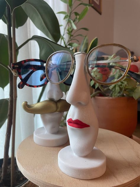 "Handmade Decor  Red lipstick If you're looking for the ideal gift for anyone obsessed with fun and organization, this desk top glasses holder is for you! A great way to keep your glasses organized and bring your smile at the same time.\" This funny and stylish glasses stand adds organization to your tabletop with a fun touch. Both personalized and functional, this product can be the perfect gift for friends or family who love order. The glasses holder made of stone material is durable and long- Mug With Face Ceramics, Pottery Glasses Holder, Clay Glasses Holder Diy, Air Dry Clay Glasses Holder, Ceramic Glasses Holder, Glasses Holder Clay, Mother Gifts Ideas, Clay Glasses Holder, Das Ideas