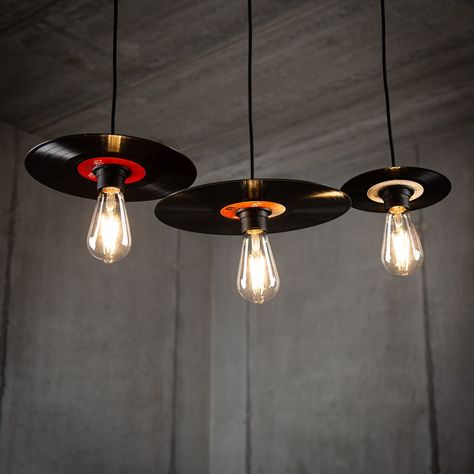 Elevate your space with a nostalgic touch and stylish ambiance by investing in our Retro Vinyl Record Lamp Pendant Set in a sleek black finish. Crafted from upcycled vinyl records, each lamp within the set is a unique piece of art, ensuring a distinct character for your lighting arrangement. 🎵💡 Available in versatile sets: - Set of 3 in 7-inch single size - Set of 3 in 10-inch EP size - Set of 3 in 12-inch LP size - Mix and match with a set featuring one of each size Handcrafted from authentic upcycled vinyl records, each lamp boasts individuality and may exhibit a variety of colors due to the upcycling process. The elegant black finish provides a modern and timeless aesthetic that complements various interior styles. Bulbs not included, offering you the flexibility to tailor the lightin Vinyl Record Ceiling, Custom Lighting Design, Record Upcycle Diy, Unique House Furniture, Music Bar Design, Retro Lamps Vintage, Old Records Crafts, Record Lamp, Artistic Lamps