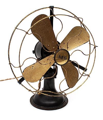 Found on www.botterweg.com - Black lackered cast iron fan type VU2 with adjustable speed and gold-coloured blades design Peter Behrens 1868-1940 executed by AEG / Germany ca.1930 Flush Ring, Ceiling Fan Parts, Wood Props, Table Fans, Antique Fans, Brass Desk, Brass Sink, Vintage Fans, Desk Fan