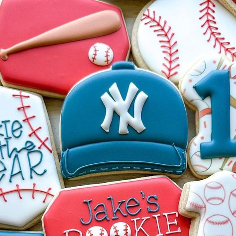 Emily’s Bake Shop on Instagram: "Jake’s Rookie Year ⚾️ I absolutely loved making these and of course including the cute baby Yankee hats to bring it all together! Can’t wait for baseball season!! • • #emilysbakeshop #customcookies #decoratedcookies #cookier #cookieart #njbaker #njcookies #sugarcookies #sugarcookiedecorating #sugarcookiemarketing #baseballcookies #rookieyearcookies #rookieyearbirthday #birthdaycookies" Baseball Sugar Cookies Decorated, Baseball Jersey Cookies Decorated, Rookie Year Cookies Baseball, Baseball Theme Decorated Cookies, Baseball Cookies With Names, Yankee Hat, Baseball Cookies, Hat Cookies, Baseball Season