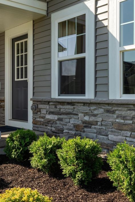 Elevate your home's exterior with stunning Dutch Quality Prestige Ledgestone. Our Dutch Quality® veneer is the perfect way to upgrade your home's exterior with stylish stone and siding combinations. Add pride and precision to your grey home exterior with a stunning stone veneer. At Instone, we've got you covered. Click this Pin to learn more today. Siding Stone Exterior, White House With Grey Stone, Exterior Vinyl Siding Ideas, Stone Exterior Ranch Style Home, Vinyl Siding With Stone Accent, Rock Front House Exterior, Grey Home Exterior With Stone, Faux Rock Siding Exterior, Exterior Siding Combinations