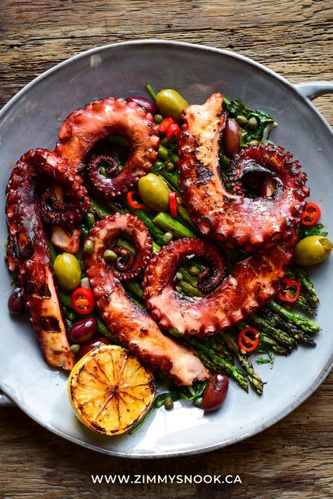 A round dish with coils of grilled octopus with grilled asparagus, wilted spinach & kale, warm olives, served with a lemon-butter, garlic, caper, parsley sauce. Warm Olives, Parsley Sauce, Octopus Recipes, Grilled Squid, Wilted Spinach, Grilled Octopus, New Year's Eve Recipes, Grilled Asparagus, Lemon Butter