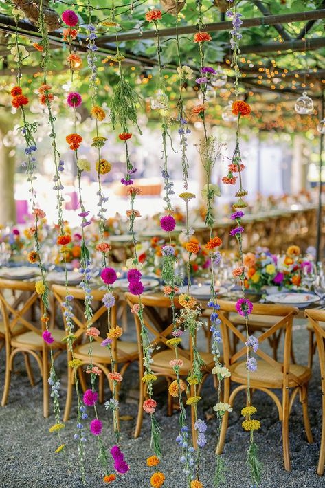 A whimsical outdoor setting with vibrant hanging floral garlands, adding a colorful and enchanting touch to the event decor. #HangingFlowers #FloralInstallation #GardenWedding #EventDecor #ColorfulGarlands Wedding Decor Romantic, Hanging Floral Installation, Wildflower Wedding Theme, Best Destination Wedding, Fairy Wedding, Hanging Flower, Wedding Planning Services, Best Wedding Planner, Salou