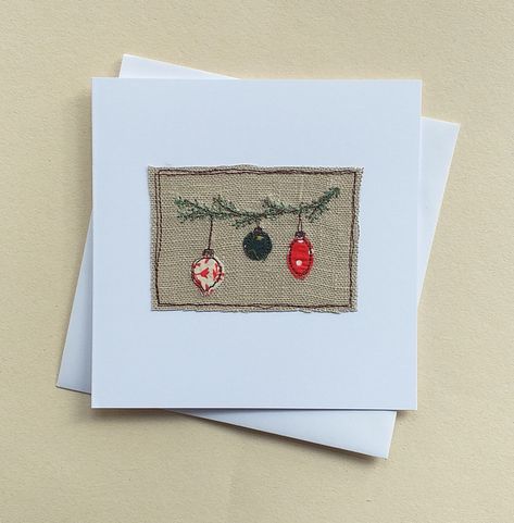 This Christmas card features 3 different baubles hanging on a pine branch. The baubles are appliqued fabric scraps stitched on to linen using free motion embroidery. The branch is embroidered in green thread. The fabric scraps will vary from card to card, but they will all be in greens and reds.  The card measures 13.5cm by 13.5cm, comes with a white envelope and in a cellophane bag for protection. Inside is left blank for your own message.  Please note that this is a handmade item, therefore th Cards Made With Fabric, Christmas Scrap Fabric Ideas, Applique Christmas, Christmas Fabric Cards, Textile Christmas Cards, Hand Sewn Christmas Cards, Free Motion Cards, Fabric Christmas Cards Free Pattern, Handmade Fabric Christmas Cards