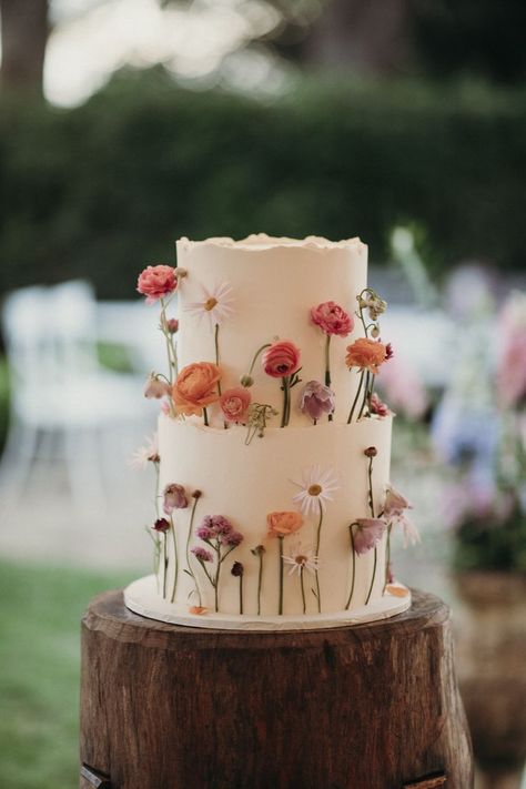 white wedding cake with dainty colourful flowers standing up around the outside Colourful Wedding Cake, Wildflower Cake, Whimsical Wedding Theme, Whimsical Wedding Cakes, Wildflower Wedding Theme, Colorful Wedding Cakes, Spring Wedding Cake, Whimsical Flowers, Floral Wedding Cake