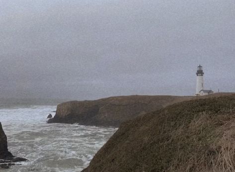 a lone lighthouse sits to the right of the image perched upon rocky cliffs which are covered in brown wintry grass. the sky is gray and foggy, and the ocean crashes against the rocks beneath the lighthouse. the waves are gray and misty. the image gives an aura of both hope and desperation. Northwest Aesthetic, Sea Coast, Living By The Sea Aesthetic, The Lighthouse, Stormy Aesthetic, To The Lighthouse Aesthetic, Coast Aesthetic, Stormy Island, Northwest Pacific