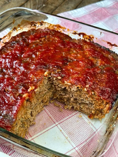 A mostly pan full of ketchup and brown sugar glazed meatloaf showing a moist, meaty filling with oats baked in a glass baking dish. Meatloaf In A Pan, Meatloaf In Cake Pan, Restaurant Meatloaf Recipes, 3lb Meatloaf Recipe, Cast Iron Meatloaf, Meatloaf Recipes Stove Top Stuffing, Loaf Pan Recipes Dinners, Meatloaf Casserole With Mashed Potatoes, Brown Sugar Meatloaf Recipes