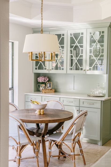 This home feels like stepping into a coastal grandmother's heaven. It includes true traditional details and materials - brass, woven textures, linen,  florals, etc. We love the cafe chairs and additional glass front cabinetry to store china, vases, etc.

Traditional Home, Coastal Grandmother, Grandmillennial, Traditional Style, Home Inspiration, Kitchen Inspo, Breakfast Nook, Charming Kitchen Breakfast Room Cabinets, Breakfast Nook Cabinets, Breakfast Nook Art, Traditional Breakfast Nook, Feminine Farmhouse, Carpenter House, Cozy Breakfast Nook, Farmhouse Kitchen Remodel, Kitchen And Bath Remodeling