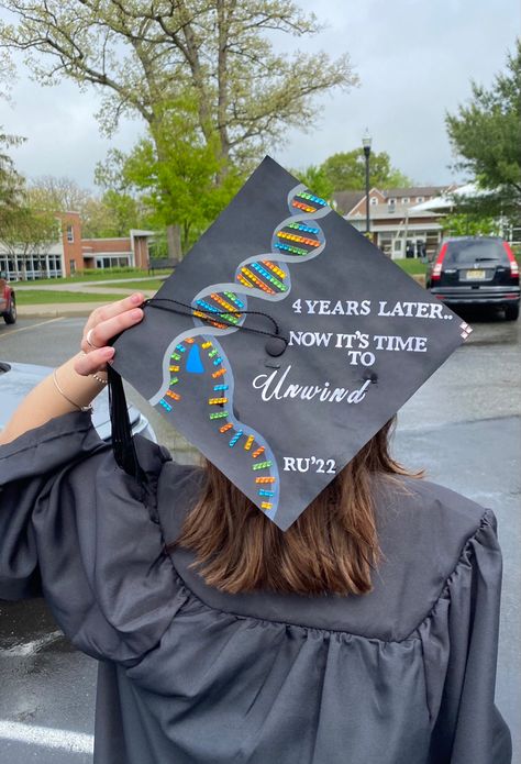 Graduation cap with a DNA helix unwinding by a DNA helicase. To the right of the DNA strand says “4 years later.. Now it’s time to unwind” Bachelors In Biology Cap, Science Graduation Cap Designs, Cap Decoration Graduation Biology, Graduation Cap Designs College Biology, Grad Cap Ideas Biology, Bachelor Of Science Graduation Cap, Graduation Cap Designs Exercise Science, Biology Graduation Party Ideas, Chemistry Graduation Cap Ideas