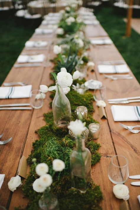 moss table runner decorated with white flowers, bottle vases and candles                                                                                                                                                                                 More Moss Wedding Decor, Moss Table Runner, Back Garden Wedding, Moss Centerpieces, Moss Wedding, Romantic Backyard, Long Table Wedding, Tafel Decor, Outdoor Dinner