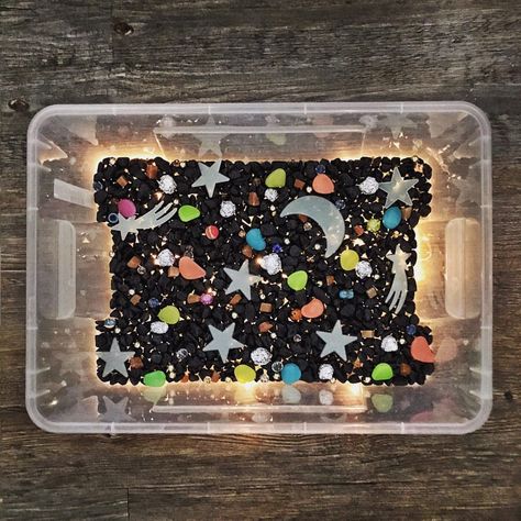 ⭐️ NIGHT SKY/ OUTER SPACE sensory bin: ⠀ Materials: ⠀• Black rocks ⠀• Aluminum foil (crumpled into balls) ⠀• Glow in the dark moon, stars, and pebbles ⠀• Assorted shiny beads ⠀• AND because I wanted my bin to be sooo extraaaa, I added FAIRY LIGHTS underneath the rocks!✨ ⠀ Swipe to see the materials in detail! 😊🌈❤️ ⠀ I wish I had 3D planet toys to include here. Anyone knows where I can get them? ⠀ ⠀ #sensorybin #sensoryplay #nightsky #outerspace #learningthroughplay #playbasedlearning #... Outer Space Sensory, Space Sensory Bin, Space Sensory, Planet Toys, Space Lessons, Black Rocks, Outer Space Theme, Sensory Lights, Sensory Crafts