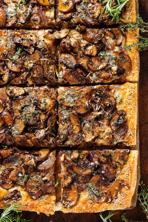 This Puff Pastry Mushroom Tart is made with three kinds of cheeses, caramelized red onions, and garlicky mushroom with rosemary and thyme. This crispy savory mushroom tart makes a great appetizer, lunch, or a light dinner. Serve it as a starter at your next party, Thanksgiving, or Christmas Eve! Mushroom And Onion Tart, Mushroom Puff Pastry Appetizers, Mushroom Tarts, Mushroom Tart, Rosemary And Thyme, Puff Pastry Tart, Feta Dip, Puff Pastry Dough, Whipped Feta