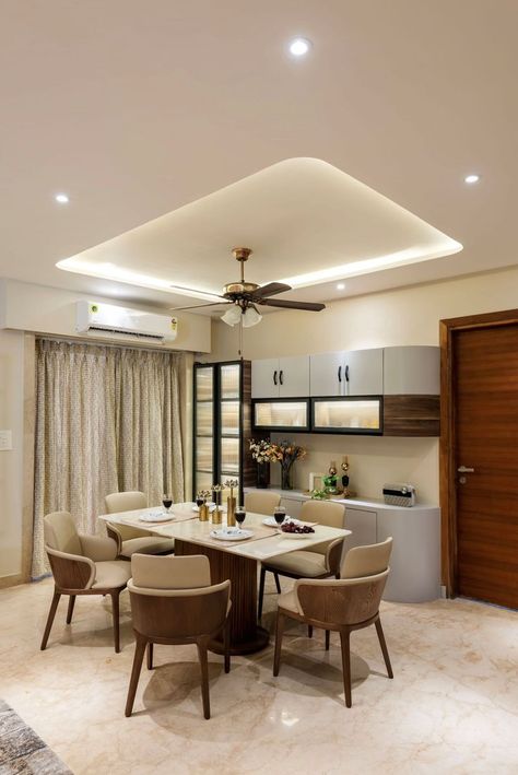 The theme of the villa is kept modern with clean lines, minimal design elements, and the use of a selective palette of materials and colors smartly designed by YnD Design Studio in Raipur,Chhattisgarh. The attractive and stylish manifestations of the concerned material in modern finishes have been beautifully used in the residence as per the client’s requirement. Latest Dining Table, Kitchen Unit Designs, Raipur Chhattisgarh, Kitchen Ceiling Design, Dining Room Furniture Design, Crockery Unit Design, Dining Table Design Modern, Colourful Living Room Decor, Interior Ceiling Design