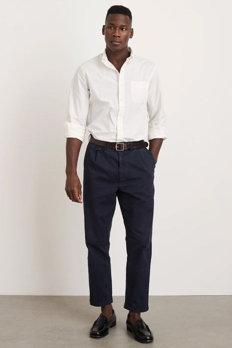 Men's cropped navy chinos, tucked in white shirt, brown leather belt and black leather penny loafers outfit. This outfit was included in the article: What Colours To Wear With Navy/Blue Pants: 8 Foolproof Shirt Options, on MensFlair.com Blue Pants Outfit Men, Navy Blue Pants Outfit, Navy Pants Outfit, Penny Loafers Outfit, Blue Pants Outfit, Wedding Fits, Pleated Pant, Loafers Outfit, Navy Chinos