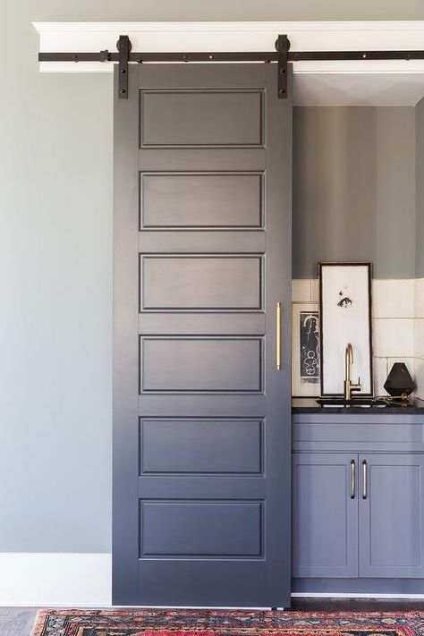 Alyssa Rosenheck Sara Ray Interior Design - A gray wet bar, finished with a gray paneled sliding door on rails, is filled with gray bar cabinets topped with black quartz fitted with a curved sink and brass gooseneck faucet. Interior Wall Sconces, Closet Bar, Hardwood Doors, Transitional Living, Oak Hill, Bar Cart Decor, Sliding Doors Interior, Sliding Barn Door Hardware, Sliding Door Hardware