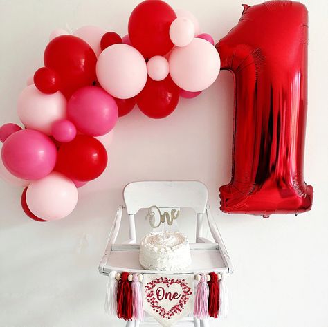 "For your Valentine baby who is turning one, this first birthday highchair banner is the perfect holiday flag to celebrate a milestone birthday.  A red and pink heart shaped frame made from tiny hearts surrounding the word \"one\" in a light red script font makes this flag a classic for their first celebration.  Banner includes 6 tassels in pale pink, red and white separated by wooden beads. Hang on a high chair or above the cake table and when the party is over hang on the wall as part of a room decoration.  This Valentine's Day love cake smash sign makes an awesome 1st birthday photo prop and keepsake. DETAILS Full banner: This 1st birthday banner comes with the center canvas banner with 2 pieces of attached double sided tape, 6 acrylic yarn tassels, and 6 wooden beads. It arrives alread Heart 1st Birthday Party, Love First Birthday Theme, Red Pink Party Decor, Valentine Bday Party, Our Little Sweetheart Is Turning One Decor, Sweet One First Birthday Valentines, Heart Theme First Birthday, Valentines Themed First Birthday, Valentines Birthday Photoshoot