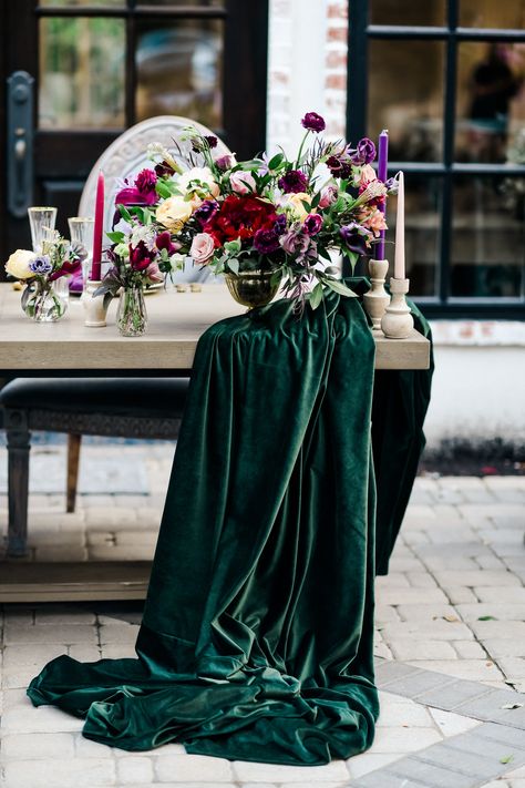 Tables are adorned with green velvet and contrasting floral tablecloths, tall, full floral arrangements, gold flatware, and gold-rimmed glassware. #falltrends #floralweddingarrangements #thewoodlands #houstonweddings #winterwedding #deephues #apricot #emerald Forest Green Bridesmaid Dresses, Velvet Table Runner, Dark Purple Wedding, Dark Green Wedding, Velvet Table, Magenta Wedding, Plum Wedding, Wedding Color Combos, Emerald Green Weddings