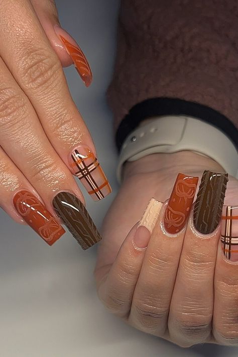 Hands with long, decorated nails featuring brown and orange plaid and patterns. Cute Thanksgiving Nails Acrylic Long, Fall Themed Nails Acrylic, Fall Nail Sets, Simple Thanksgiving Nails, Short Thanksgiving Nails, Fall Sets Nails, Thanksgiving Nail Art Designs, Thanksgiving Nails Color, Thanksgiving Nails Design Fall