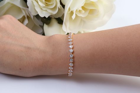 At the first mention of a diamond bracelet, it’s hard to imagine anything but a tennis bracelet. The iconic style—which does have a connection to the sport of tennis—first came on the jewelry scene in the 1920s and was originally known as a diamond line bracelet before earning its tennis title. The bracelet’s modern name was “coined after women’s t... Tenis Bracelet, Diamond Education, Fancy Color Diamonds, Tennis Bracelet Diamond, Custom Engagement Ring, Emerald Cut Diamonds, Brilliant Diamond, Blue Bracelet, Tennis Bracelet