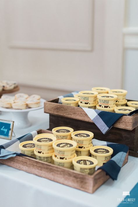 This blue bell ice cream wedding dessert bar in wood trays was such a unique idea for any bride looking for something simple or rustic while staying on a budget.  | Planned & Designed by Dallas Fort Worth Wedding Planners Shannon Rose Events | Be sure to click the link below for more wedding ideas & inspiration! Ice Cream Table Wedding, Mini Ice Cream Bar, Individual Ice Cream Cups, Diy Ice Cream Bar Wedding, Ice Cream Wedding Dessert, Ice Cream Display Ideas, Blue Wedding Desserts, Ice Cream Wedding Reception, Cobbler Wedding Dessert